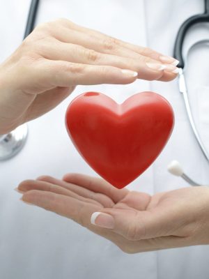 Female doctor with the stethoscope holding heart